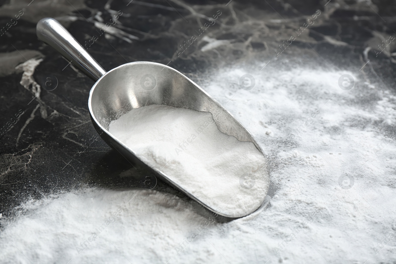 Photo of Scoop and baking soda on grey background