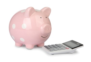 Photo of Piggy bank and calculator isolated on white