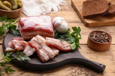 Pork fatback, garlic and parsley on wooden table