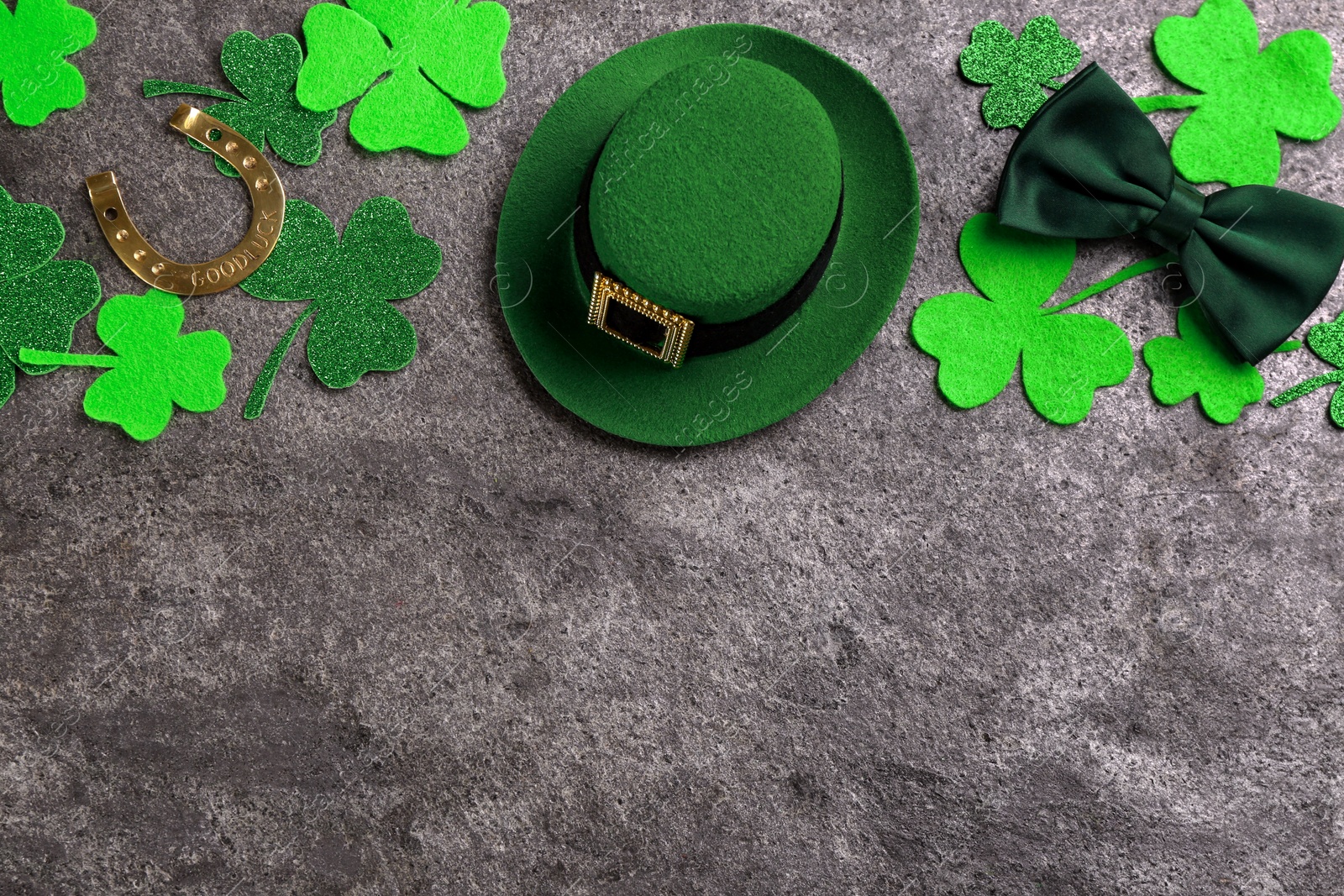 Photo of Leprechaun's hat and St. Patrick's day decor on grey stone background, flat lay. Space for text