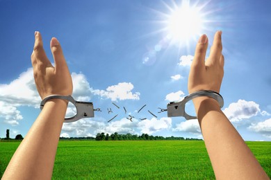 Freedom. Woman with broken handcuffs on her hands outdoors, closeup