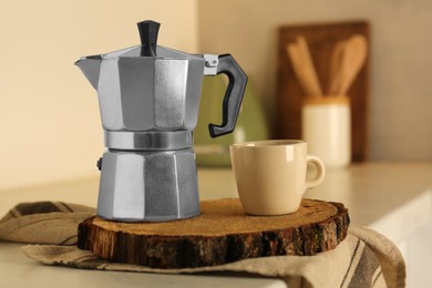 Photo of Cup of coffee and moka pot on light countertop in kitchen