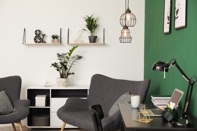 Photo of Modern living room interior with workplace near green wall