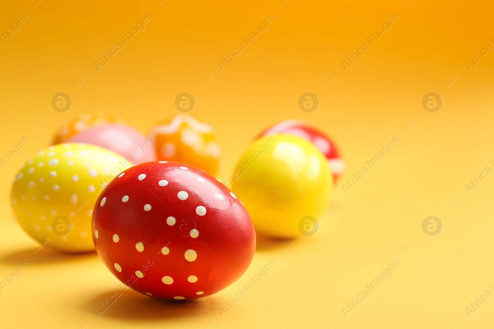 Photo of Painted Easter eggs on color background, space for text