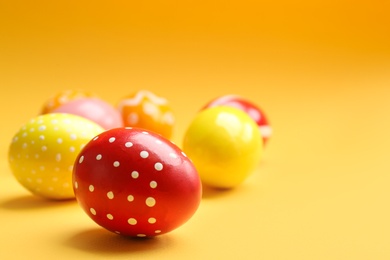 Painted Easter eggs on color background, space for text