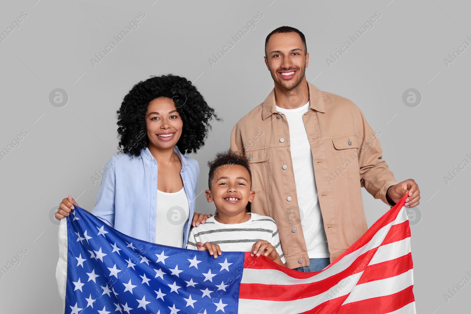 Photo of 4th of July - Independence Day of USA. Happy family with American flag on light grey background