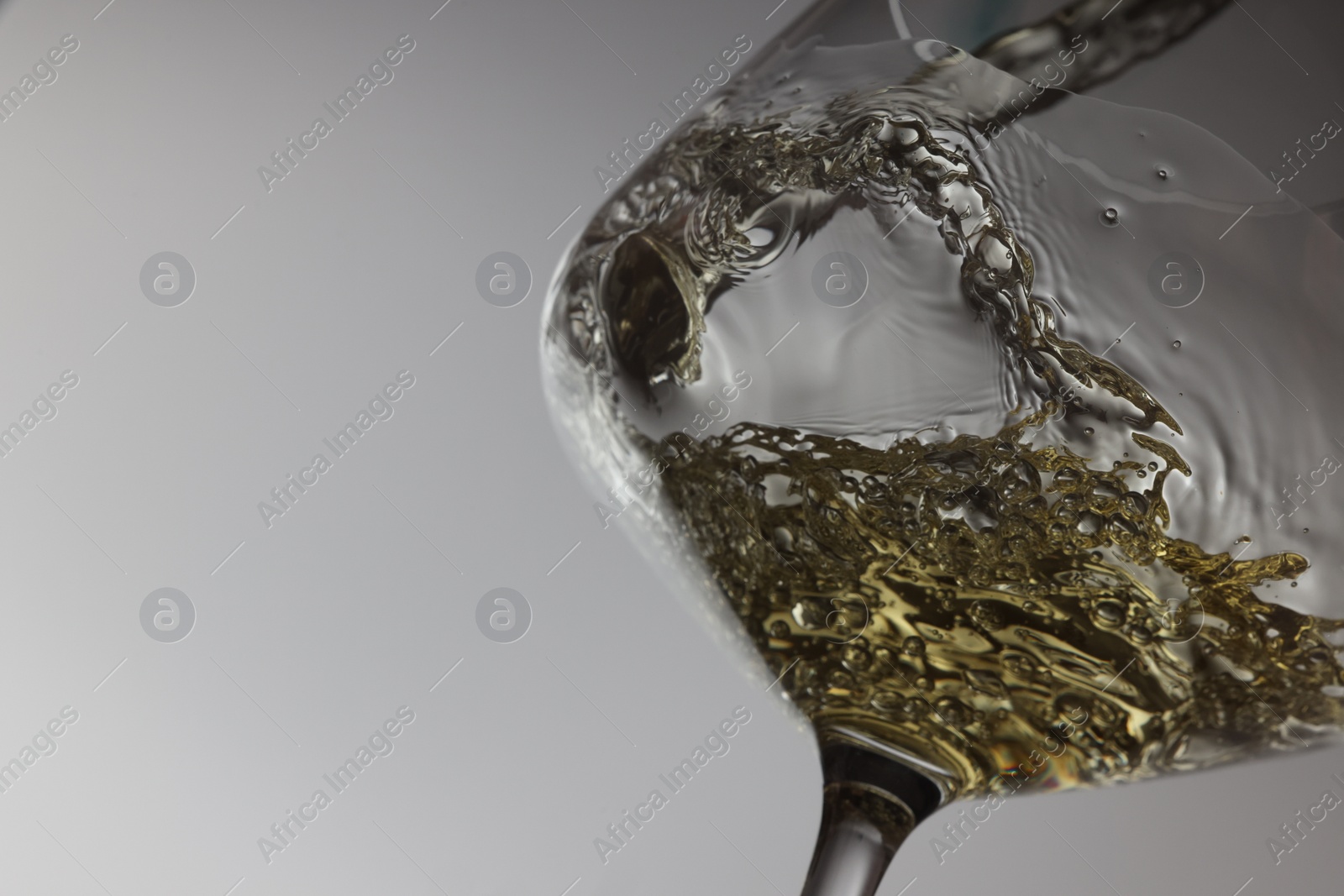 Photo of Tasty aromatic wine in glass on gray background, closeup. Space for text