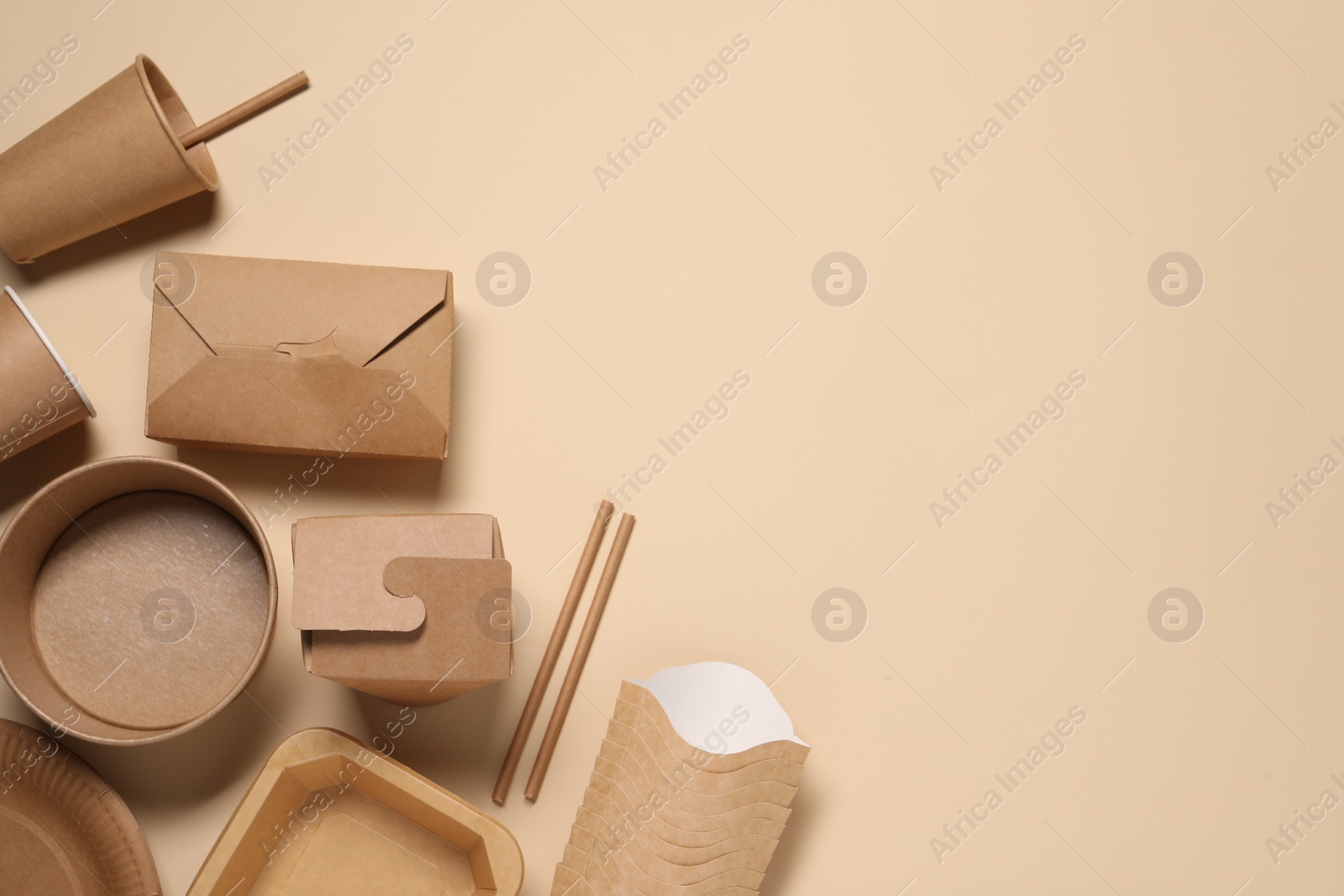 Photo of Eco friendly food packaging. Different paper containers on beige background, flat lay. Space for text