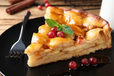 Photo of Slice of traditional apple pie with berries on plate, closeup