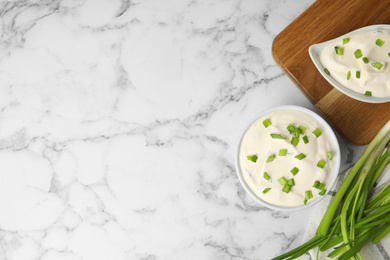 Photo of Fresh sour cream with onion on white marble table, flat lay. Space for text
