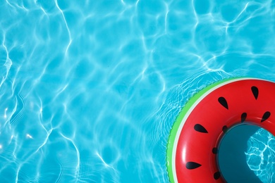 Inflatable ring floating in swimming pool on sunny day, top view with space for text