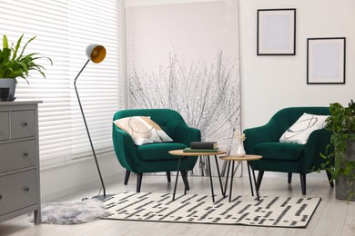 Photo of Comfortable armchairs and nesting tables in stylish room