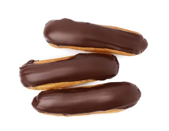 Photo of Delicious eclairs covered with chocolate isolated on white, top view