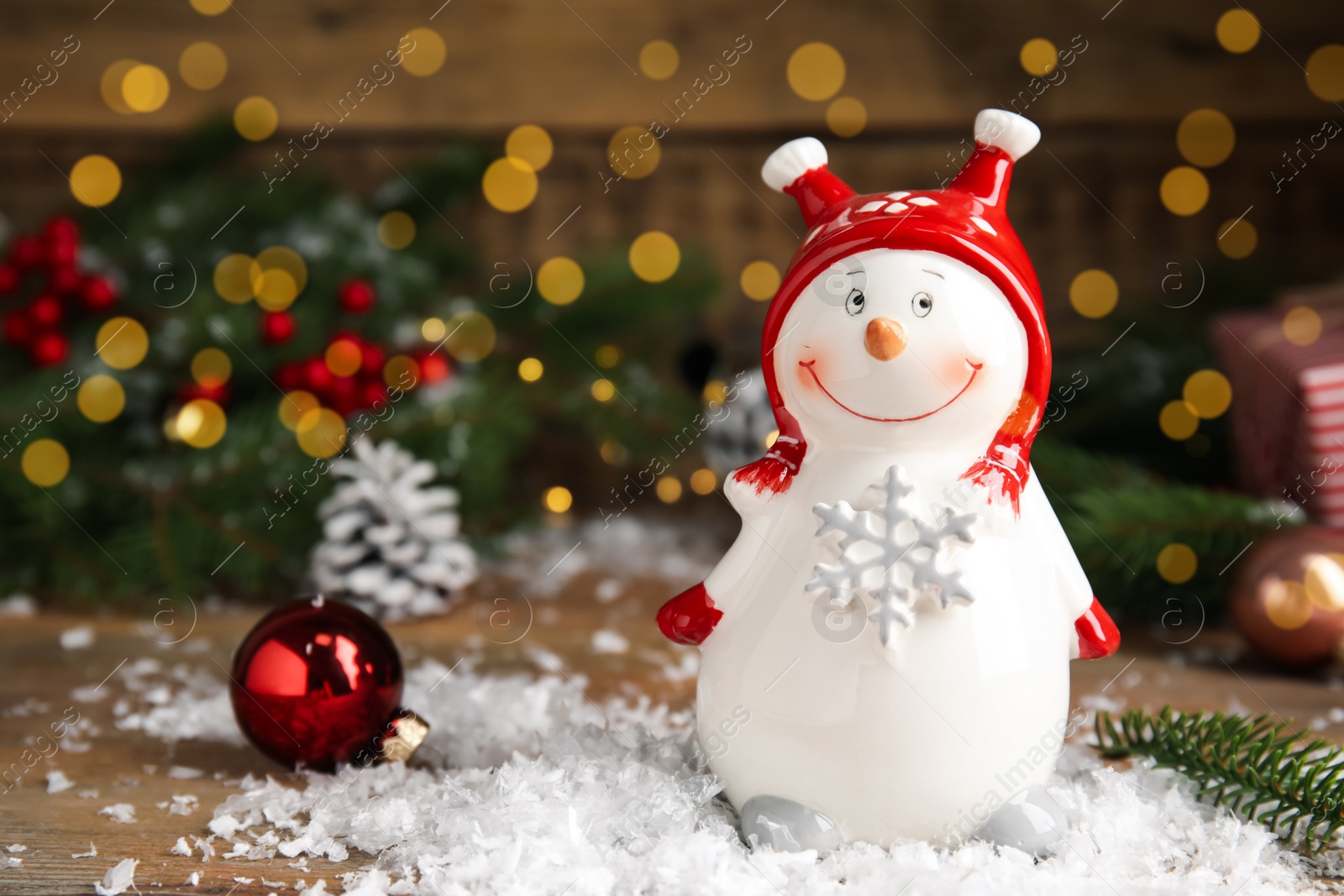 Photo of Cute snowman and Christmas decor on table