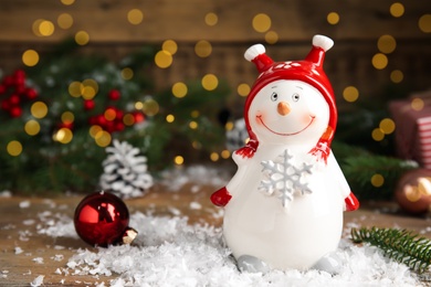 Photo of Cute snowman and Christmas decor on table