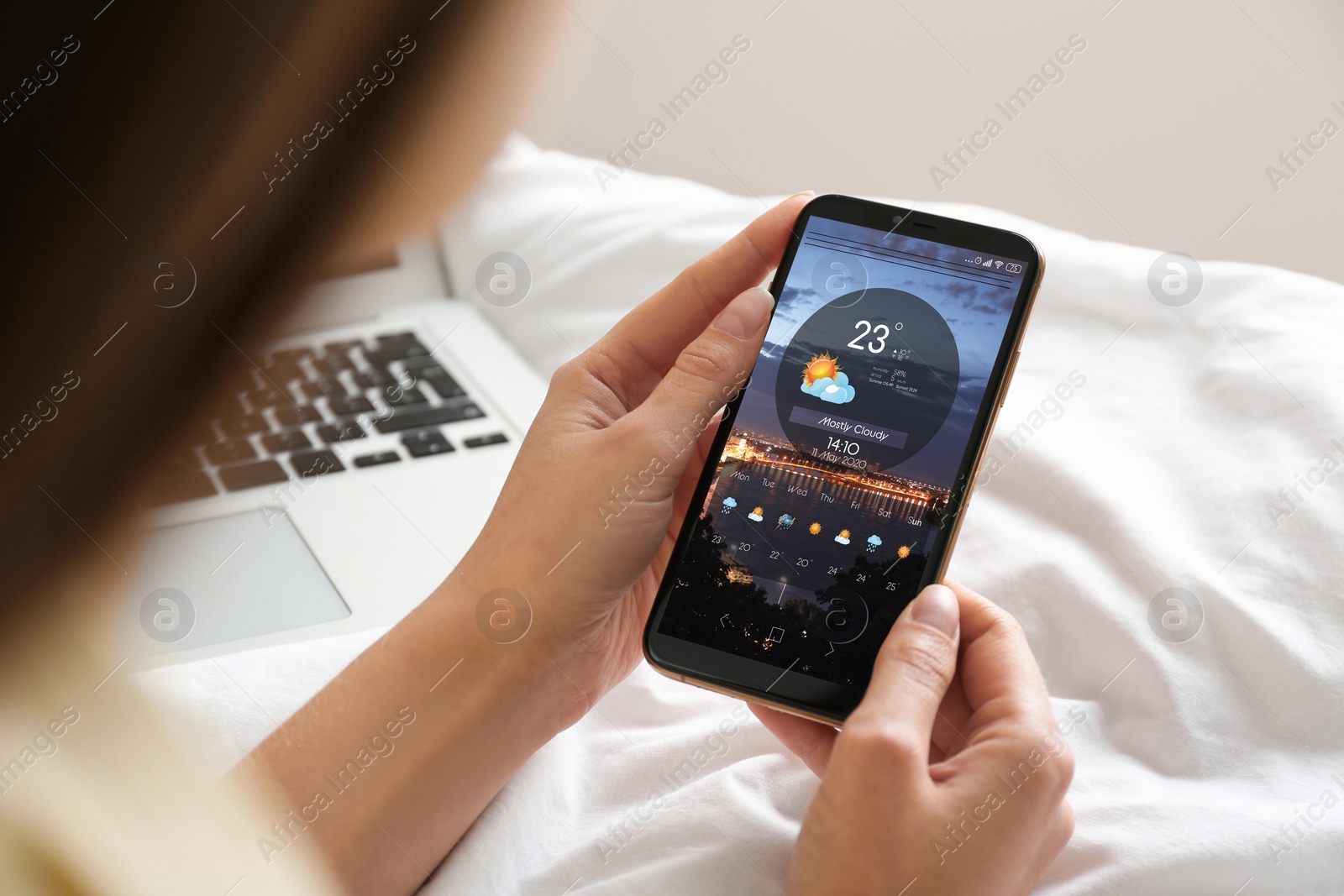 Image of Woman using weather forecast app on smartphone at home, closeup