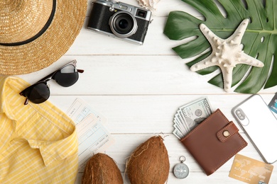 Flat lay composition with tourist items for beach vacation on wooden background, space for text. Travel agency