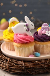 Photo of Tasty decorated Easter cupcakes on wooden table