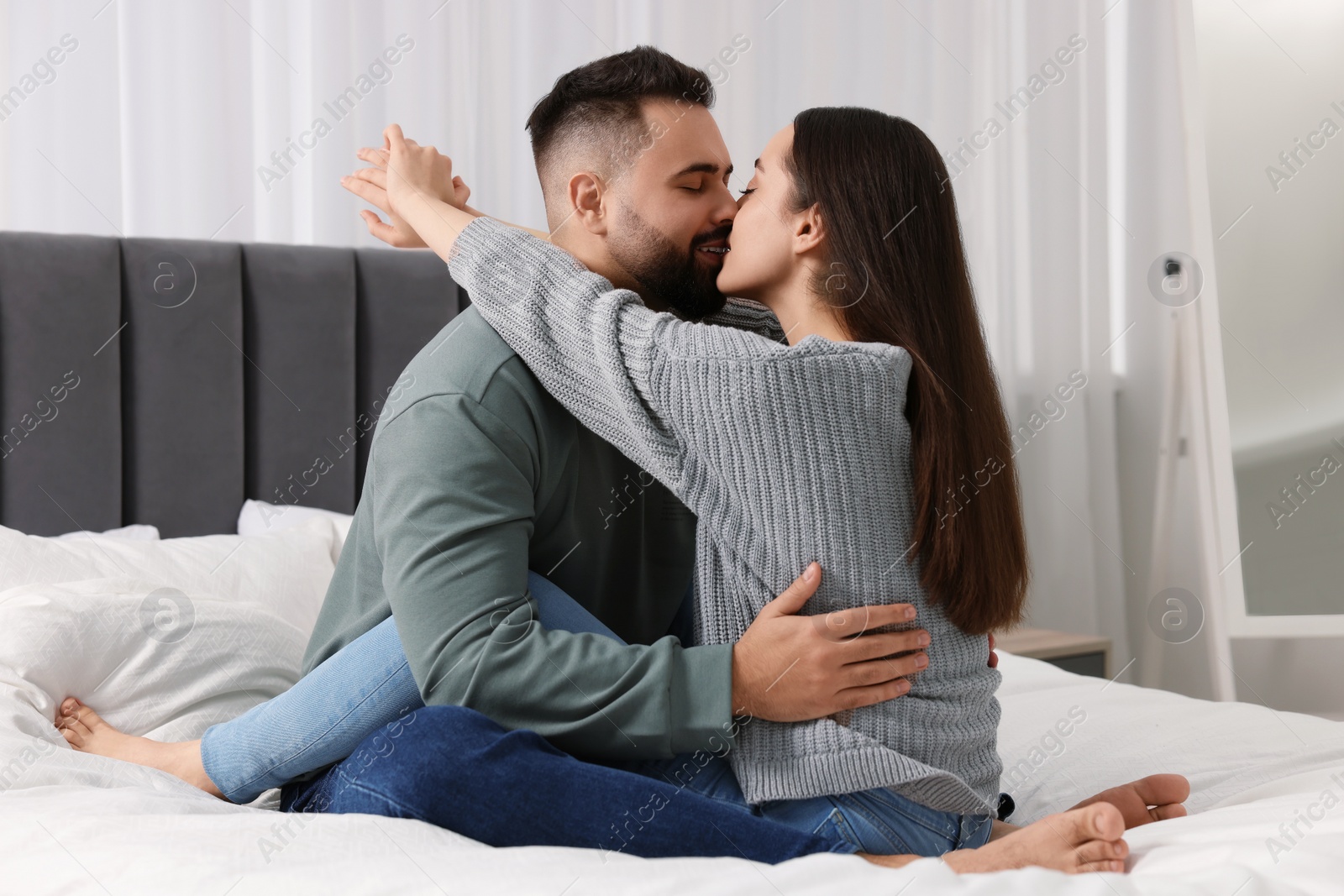 Photo of Cute relationship. Affectionate young couple kissing in bedroom