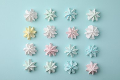 Photo of Delicious meringue cookies on light blue background, flat lay