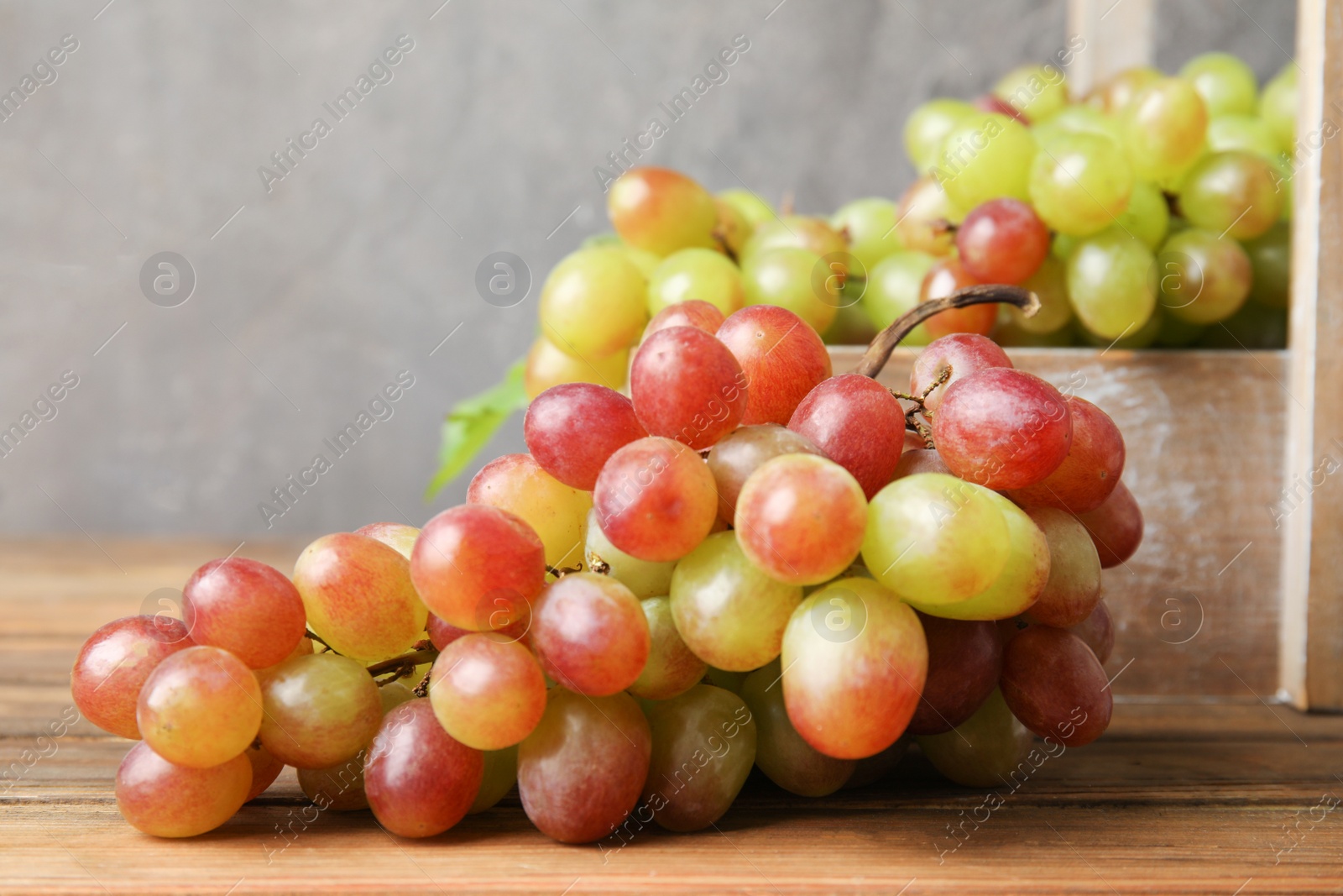 Photo of Fresh ripe juicy grapes on table against blurred background