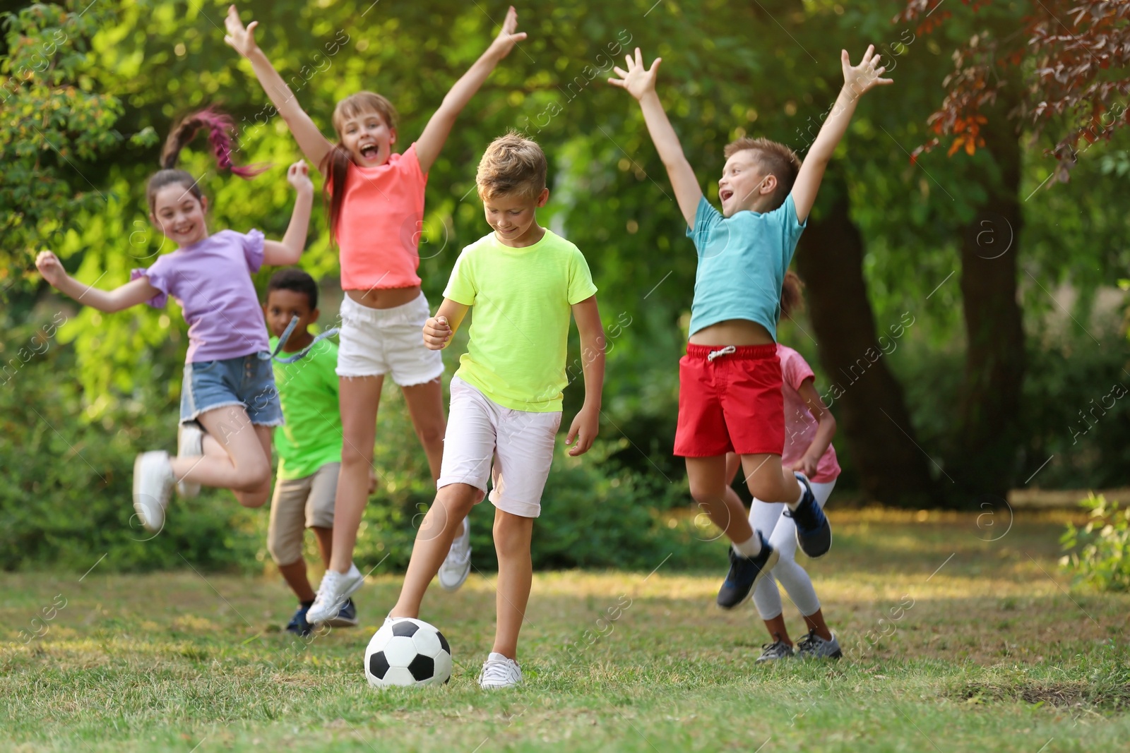 Photo of Cute little children playing with soccer ball in park