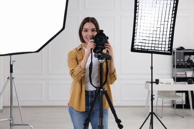 Photo of Professional photographer working with camera in modern photo studio
