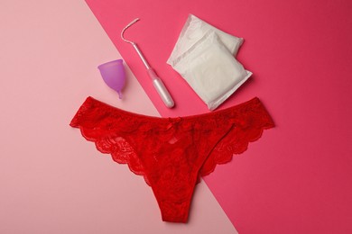 Photo of Panties, menstrual cup, pads and tampon on color background, flat lay