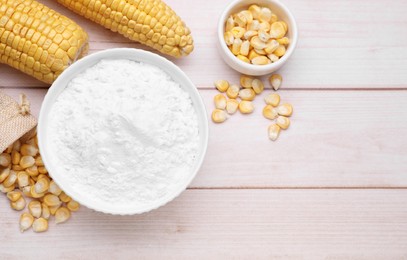 Photo of Bowl with corn starch, ripe cobs and kernels on wooden table, flat lay. Space for text