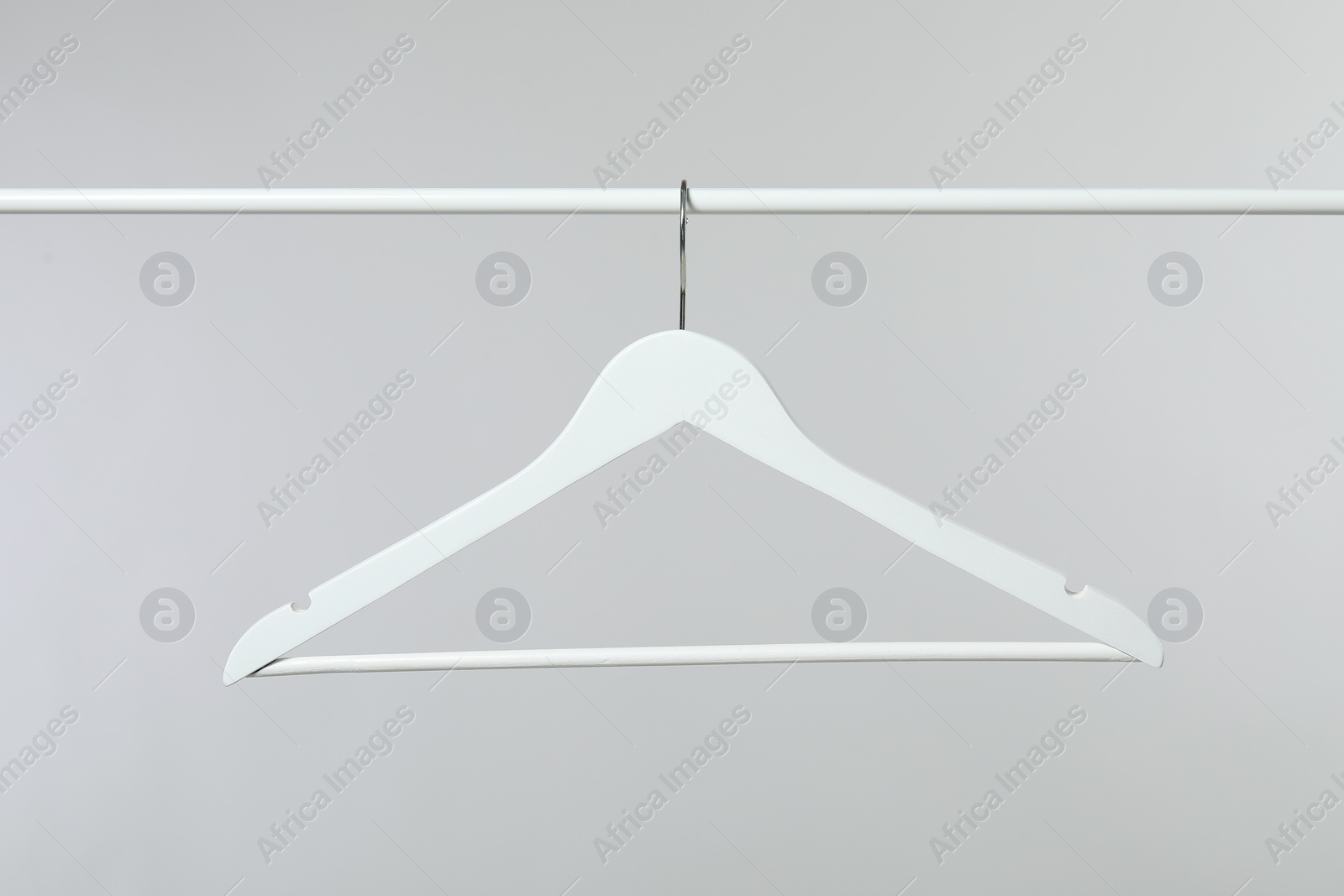 Photo of Empty clothes hanger on rack against light grey background