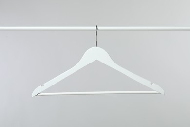 Photo of Empty clothes hanger on rack against light grey background