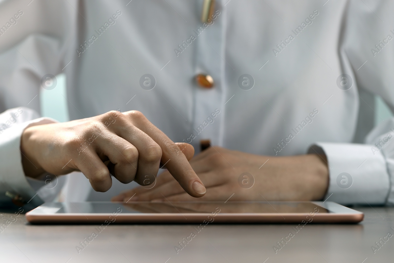 Photo of Closeup view of woman using modern tablet at table