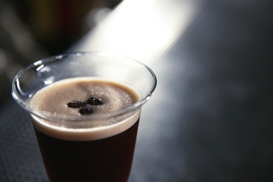 Photo of Glass of martini espresso cocktail in bar, closeup. Space for text
