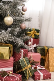 Many different gifts under Christmas tree indoors