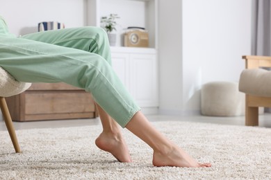 Woman on soft light brown carpet at home, closeup. Space for text