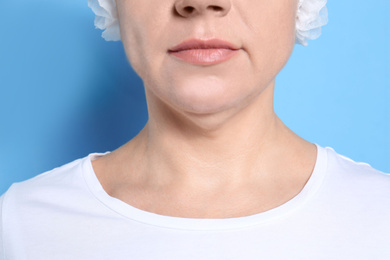 Photo of Mature woman with double chin on blue background, closeup