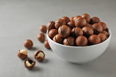Photo of Bowl with organic Macadamia nuts and space for text on grey background