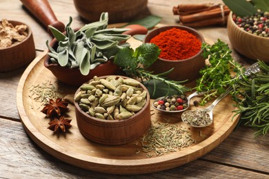 Photo of Different herbs and spices on wooden table