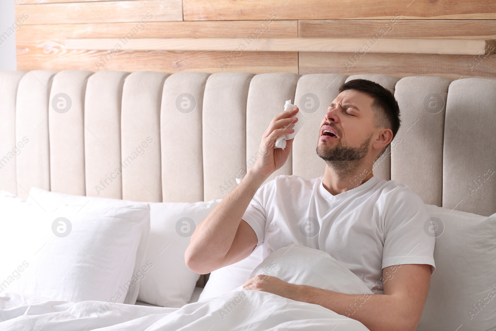 Photo of Man suffering from runny nose in bed