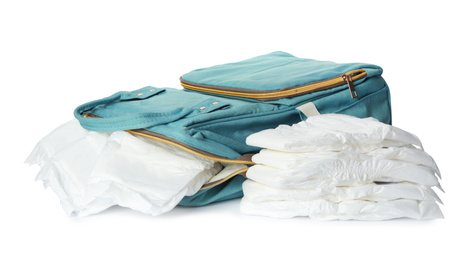 Photo of Backpack and disposable diapers on white background