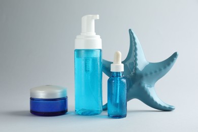 Photo of Set of cosmetic products and decorative starfish on light grey background