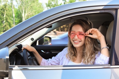 Photo of Happy woman with heart shaped glasses in car