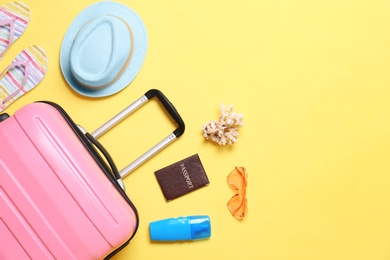 Photo of Flat lay composition with suitcase and beach objects on yellow background. Space for text