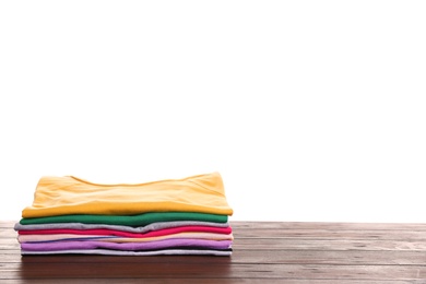 Photo of Pile of ironed clothes on table against white background. Space for text