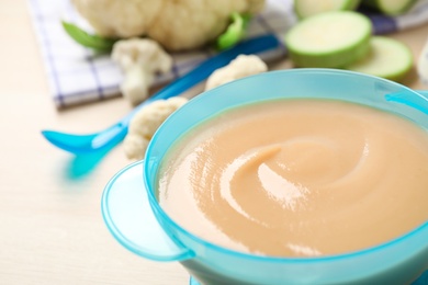 Photo of Healthy baby food in bowl on table, closeup