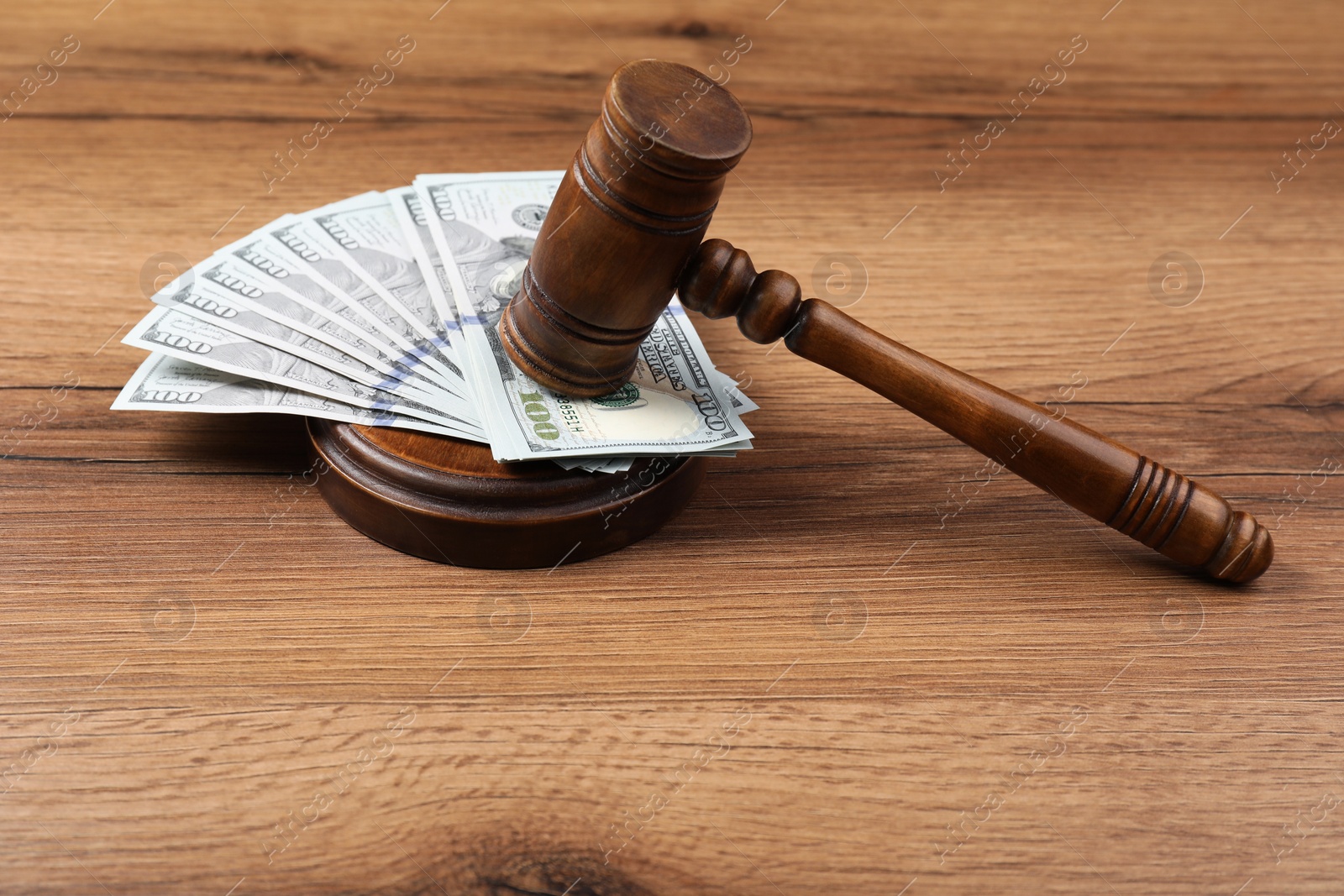 Photo of Judge's gavel and money on wooden table