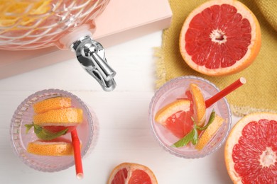 Delicious refreshing drink with grapefruit and mint on white wooden table, flat lay