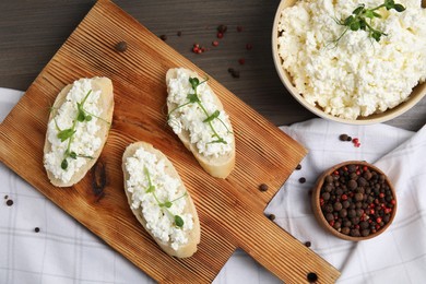 Bread with cottage cheese and microgreens on wooden table, flat lay