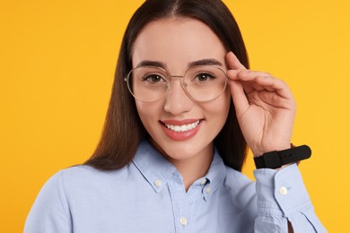 Photo of Beautiful woman wearing glasses on orange background