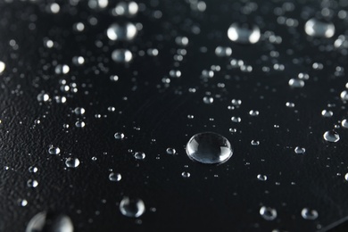 Photo of Many clean water drops on black background